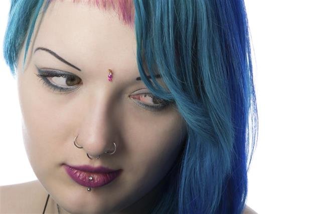 Young woman looking down with sad smile.
