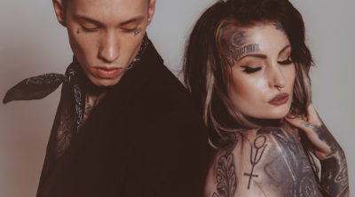 Couple with tattoos - back to back